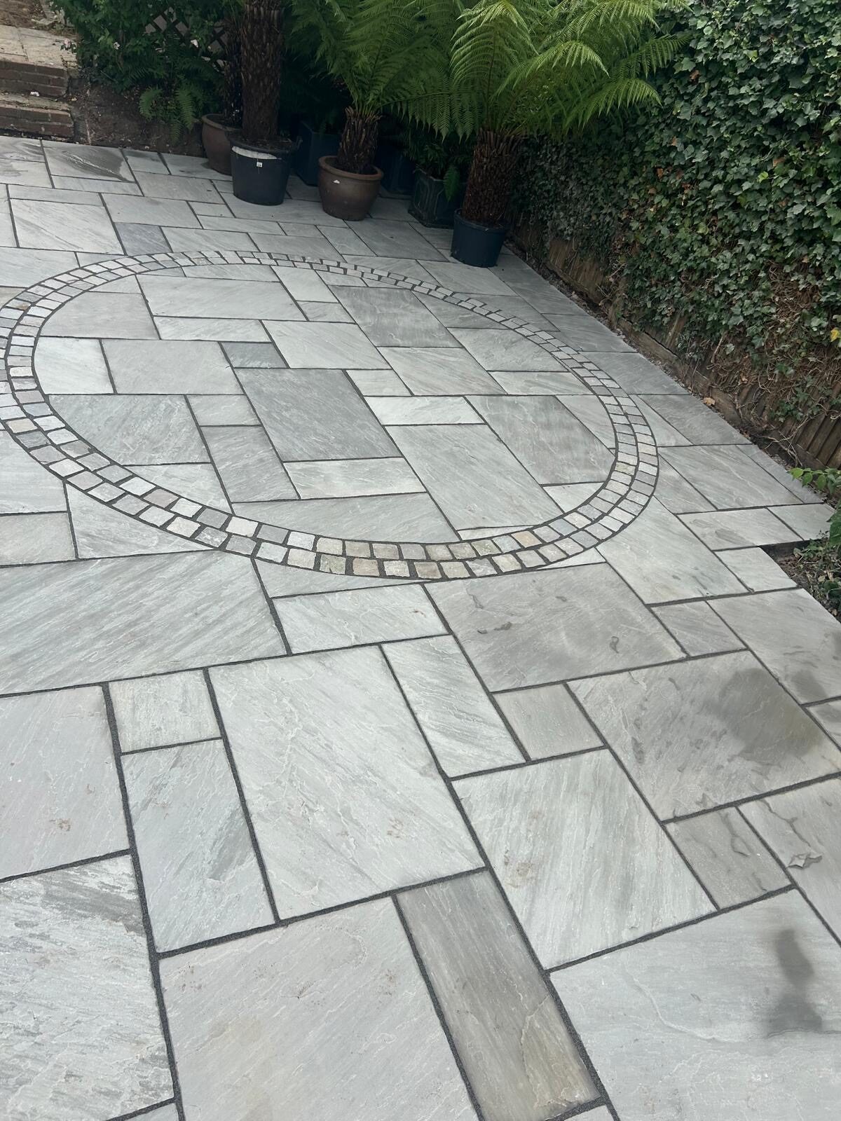 Patio with circular paving feature and border detail in Surrey