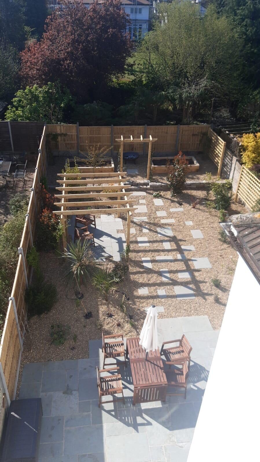 Paved garden seating area with pergola in Surrey