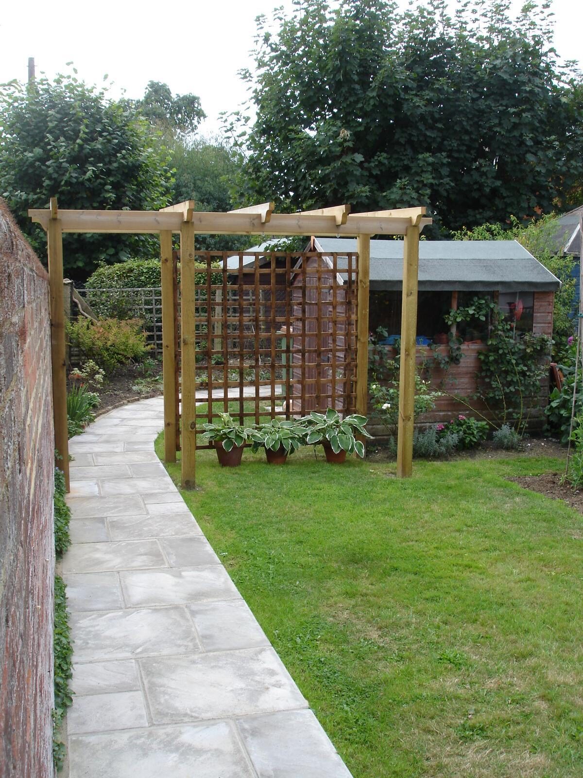 Timber pergola walkway over a landscaped garden path in Surrey