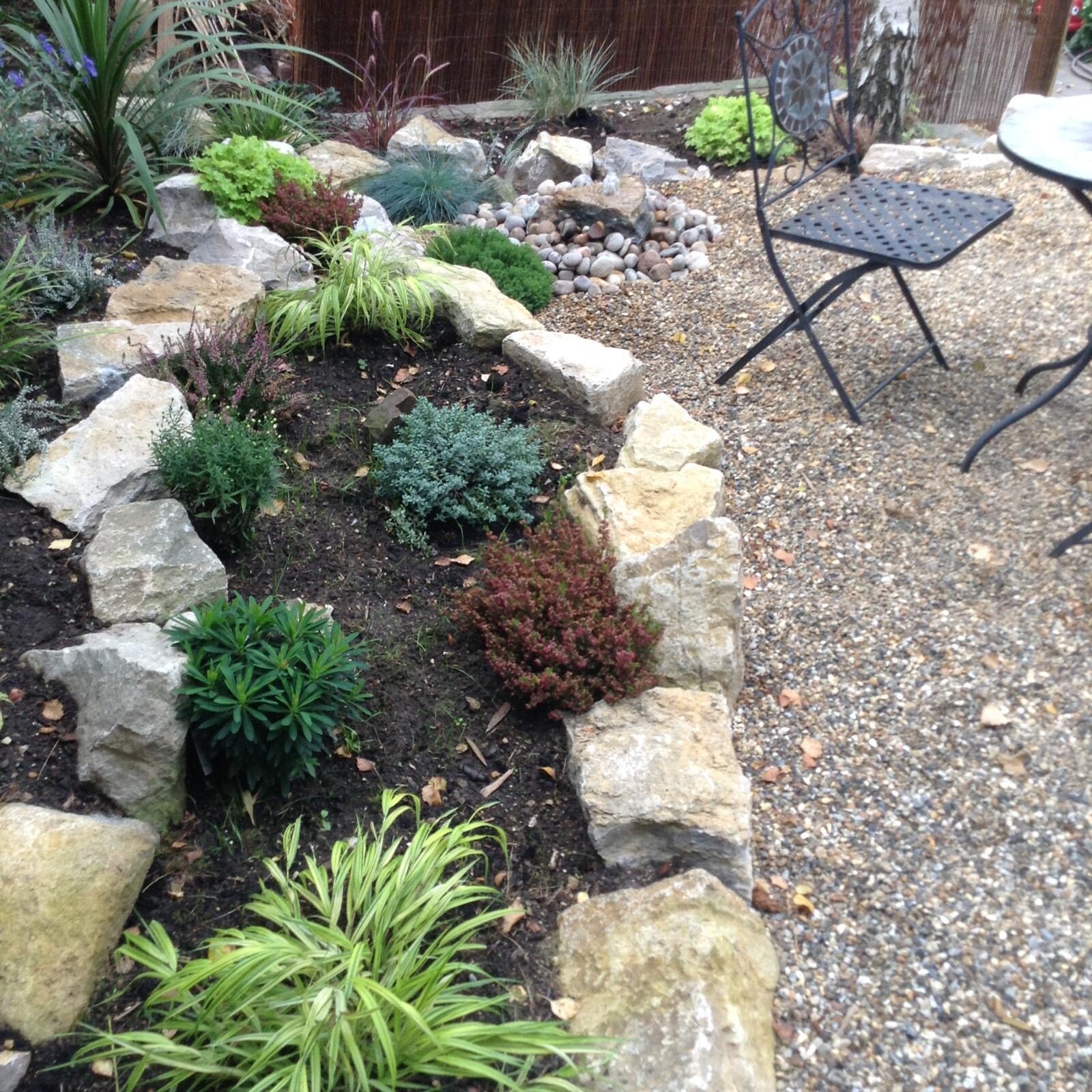 Landscaped garden with rockery, mature planting and lawn in Surrey