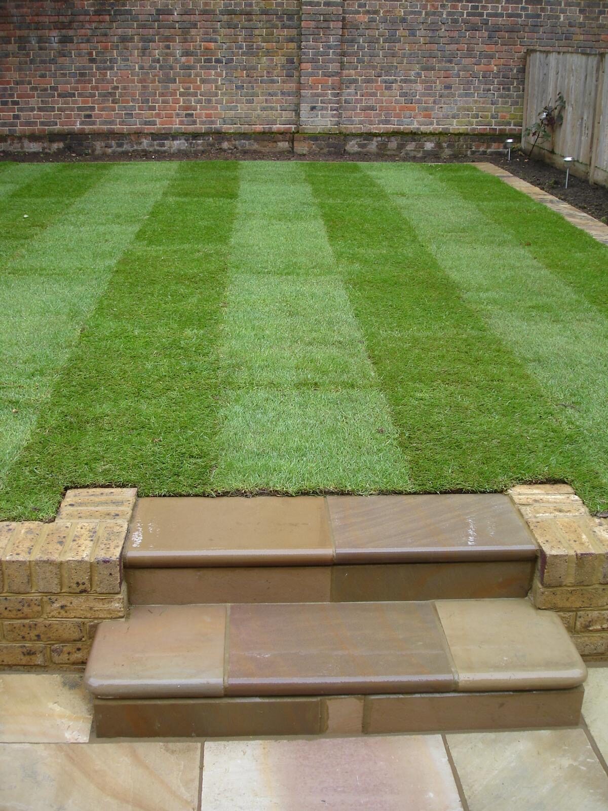 Landscaped garden with sleeper steps and turf in Surrey