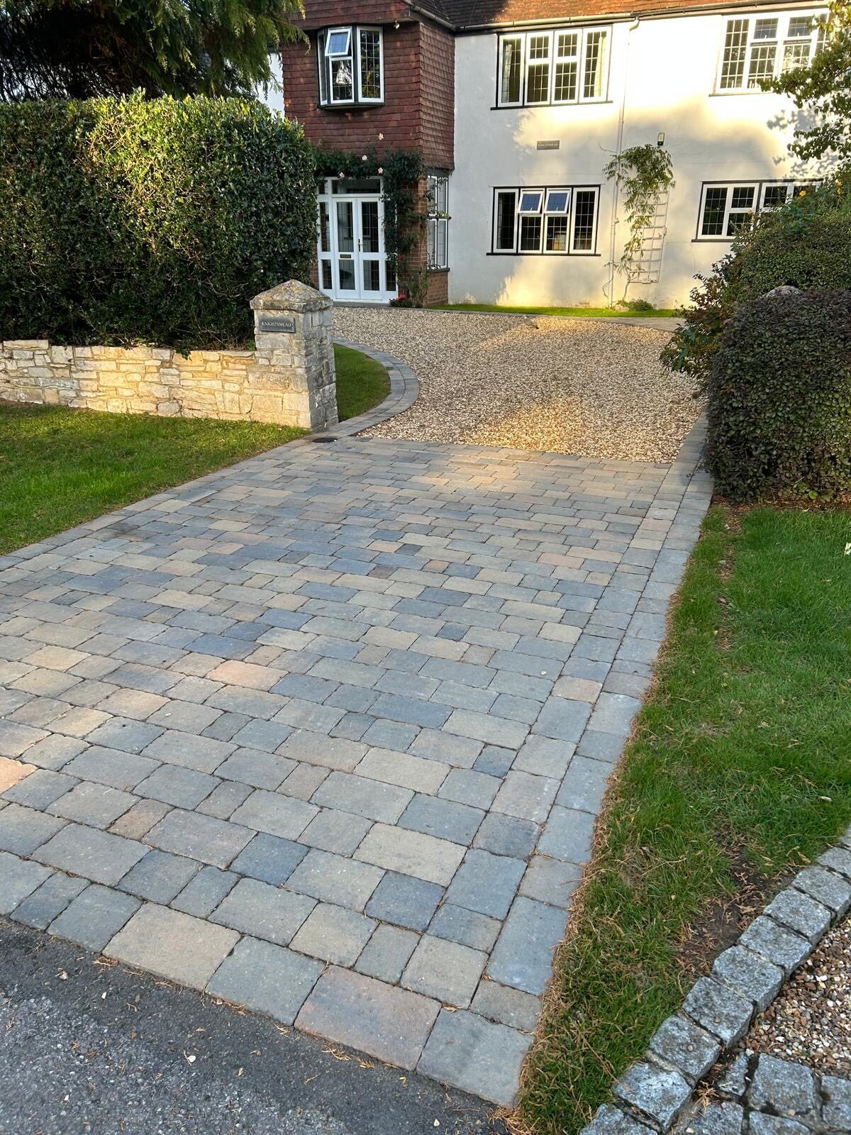 Grey stone-paved driveway with planting in Surrey