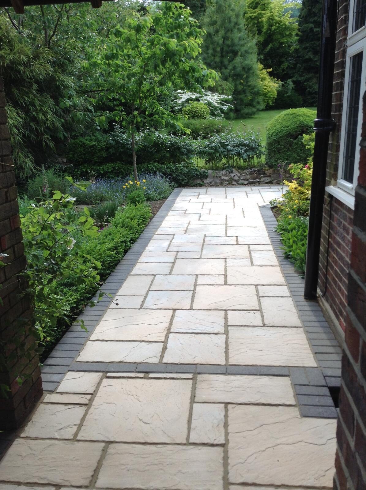 Grey porcelain patio and path with lawn in Surrey