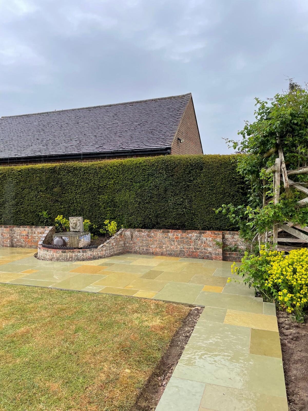 Curved sandstone patio with lawn in Surrey